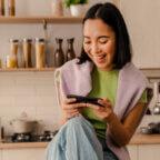 Smiling person looks at phone making a Google appointment with a healthcare provider