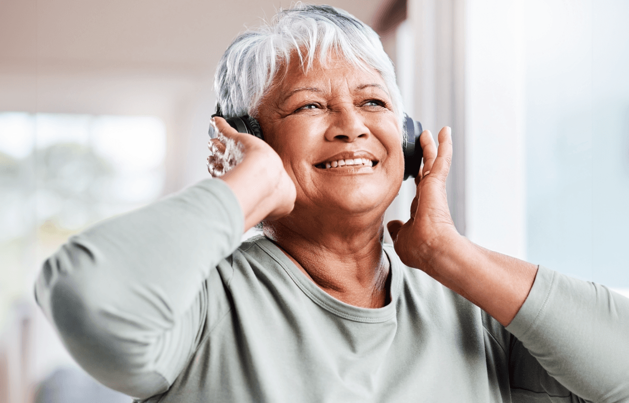 older femme person listening to music in headphones