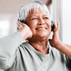 older femme person listening to music in headphones