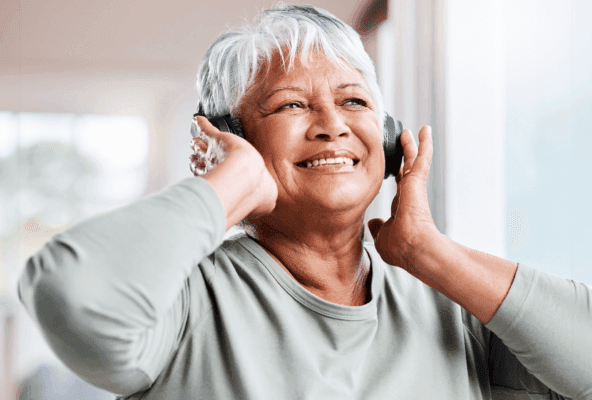 older femme person listening to music in headphones