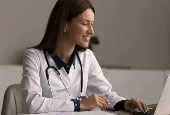 female healthcare professional looking at laptop