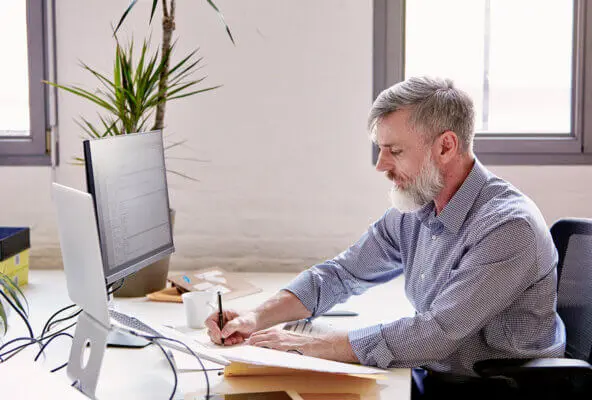 Man sending collections letter to patient on computer