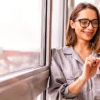 Patient smiles while looking at phone, appreciating automatic appointment reminders