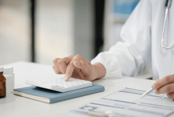 doctor pictured using calculate to calculate mental health services