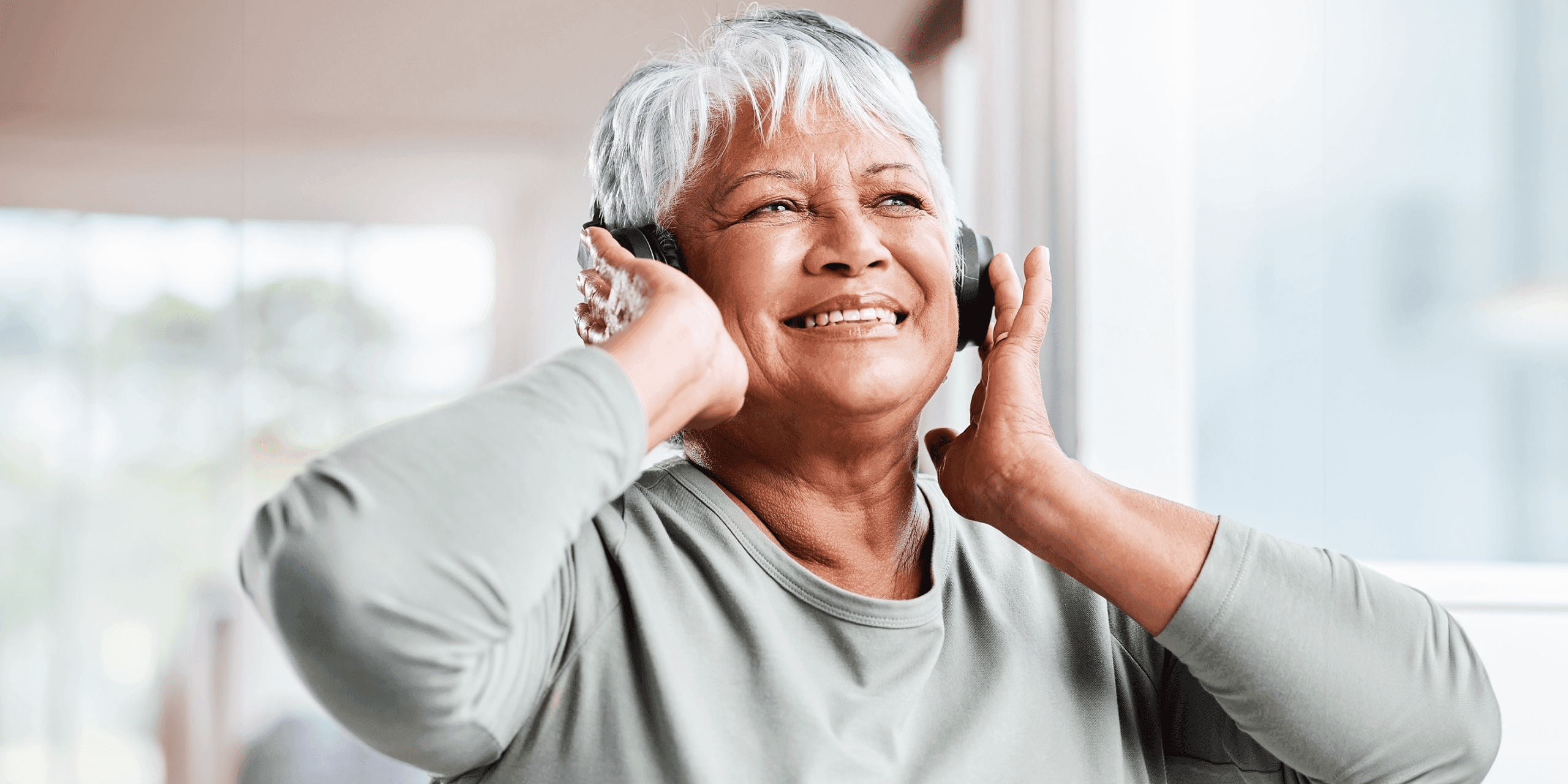 older femme person listening to music in headphones
