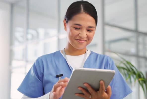 Medical professional reads about history of electronic health records on tablet