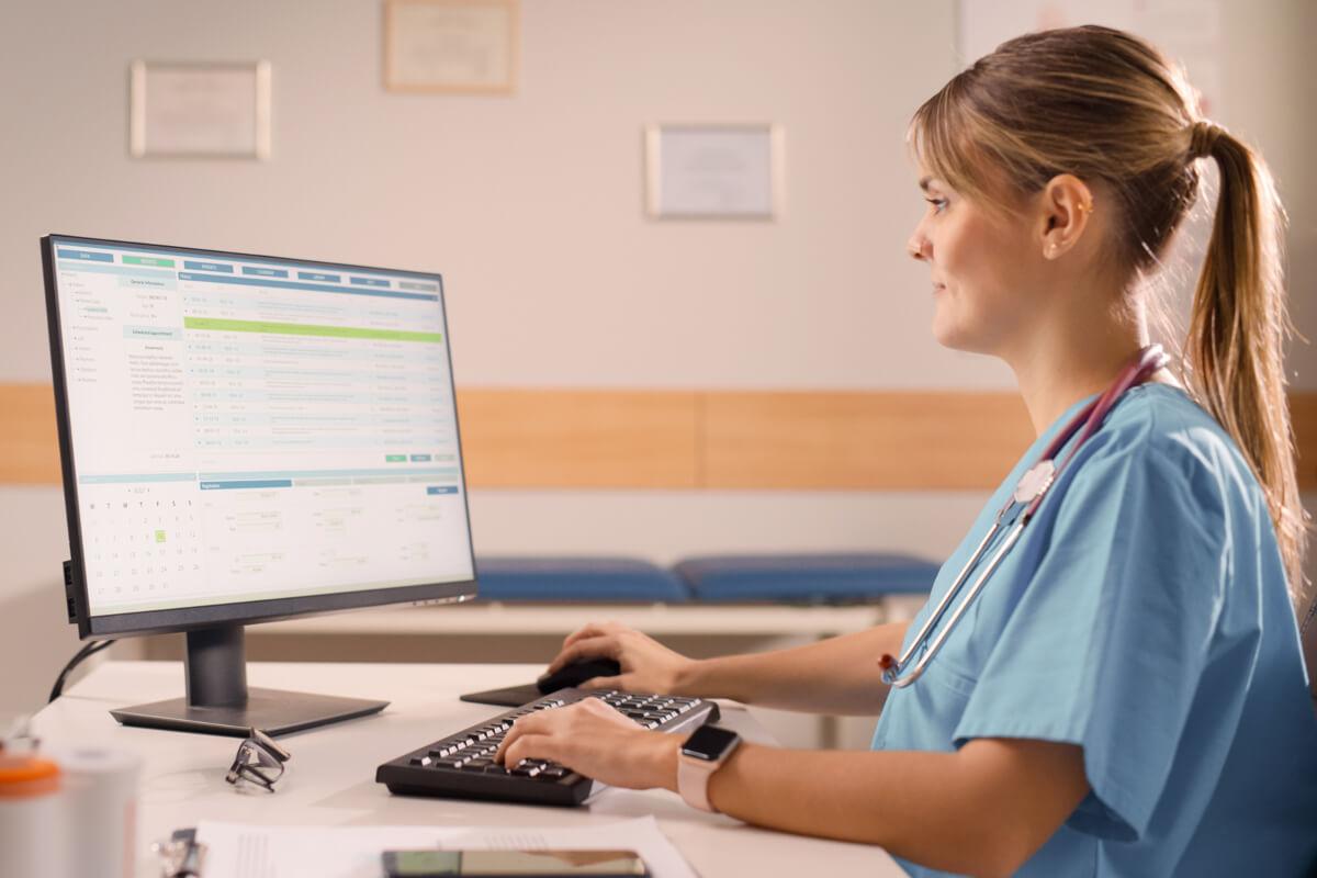 Physician looks at billing software on computer after reading August 2025 RCM healthcare news